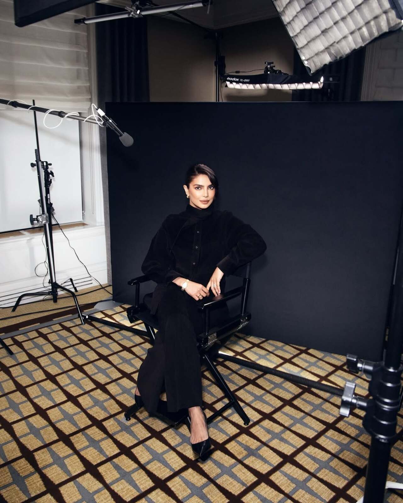 Effortless authority meets modern elegance. Seated like the icon she is, Priyanka pairs her sumptuous black velvet set with classic black pumps and delicate jewelry. The sleek hair and defined eyes complete a look that is equal parts powerful and polished